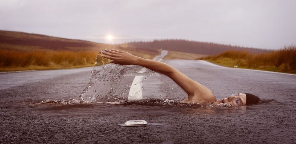 Abstract image of lady swimming across and within a road