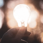 Image of a lit up lightbulb being held in someone's hand